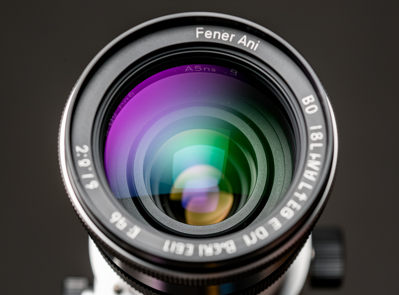 Close-up of an apochromatic refractor telescope multi-element lens showing anti-reflection coating colors