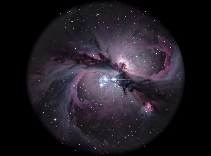 Telescope view of the Orion Nebula M42 with glowing gas clouds and the trapezium star cluster