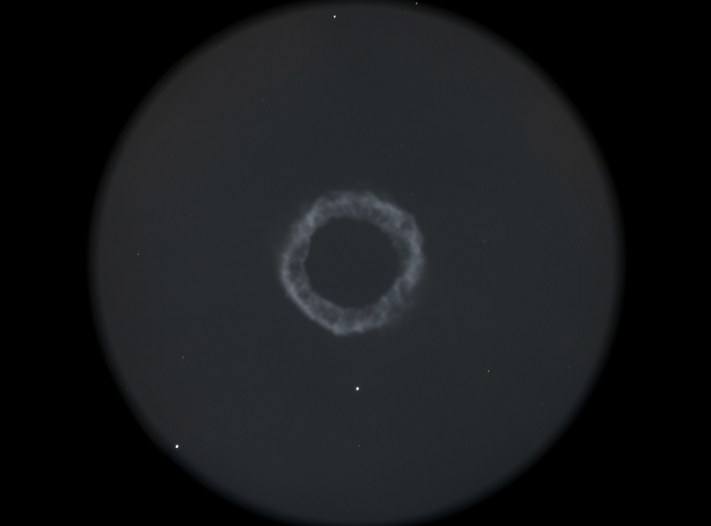 Ring Nebula M57 appearing as a small gray smoke ring at high magnification in a telescope