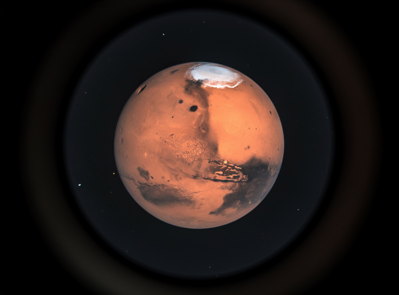 Mars showing polar ice cap and dark surface features during opposition