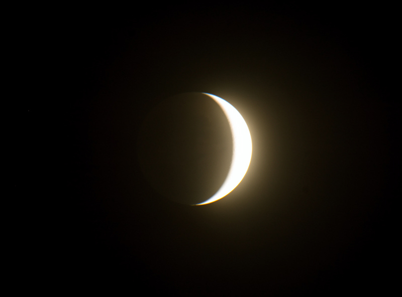 Venus showing half-moon phase through telescope against dark sky