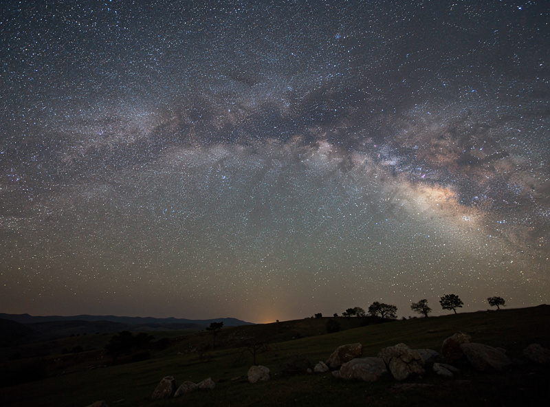 Milky Way captured with star tracker mount and wide-angle camera lens over dark landscape