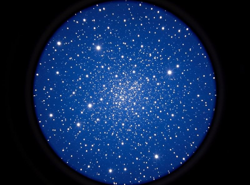 View through a telescope focuser showing a bright low-power star field, illustrating exit pupil and true field of view