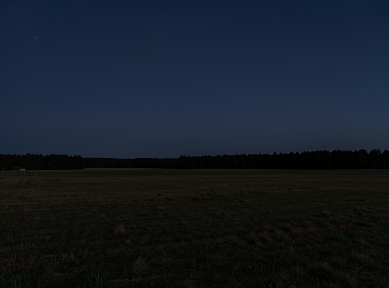 Open rural field with a clear unobstructed horizon at twilight, ideal dark sky observing site