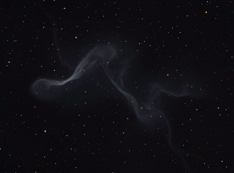 Faint structured nebula filaments seen through a telescope eyepiece view