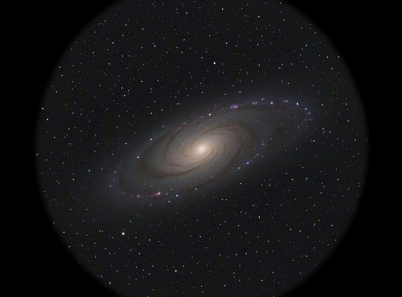 Faint spiral galaxy as seen through a telescope eyepiece against a dark spring sky