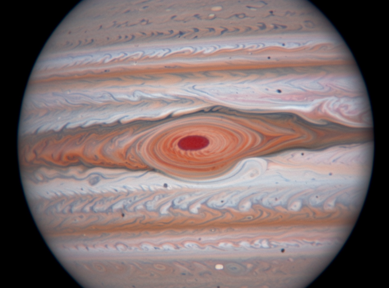 Detailed telescope view of Jupiter showing the Great Red Spot as an oval storm in a cloud belt with festoons