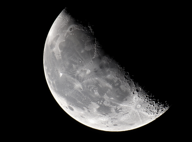 View of the crescent Moon showing crater detail along the terminator as seen through binoculars